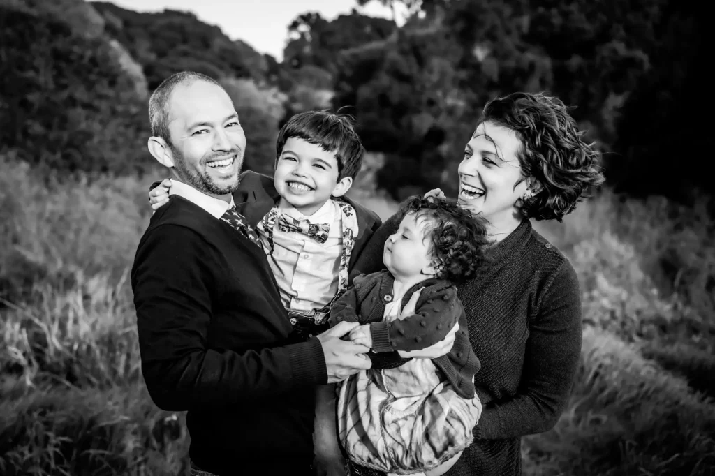 Black and white portrait of laughing family by photographer Shelly Rivoli