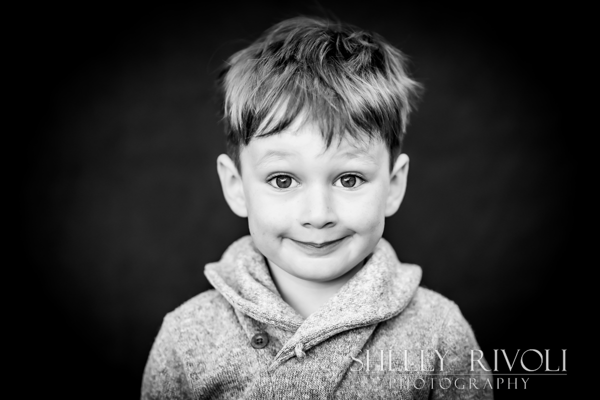 Young boy withhilarious expression for a black and white children's portrait by photographer Shelly Rivoli